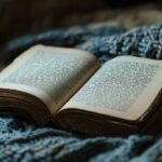 An open book resting on a textured blue blanket, inviting a sense of warmth and calm